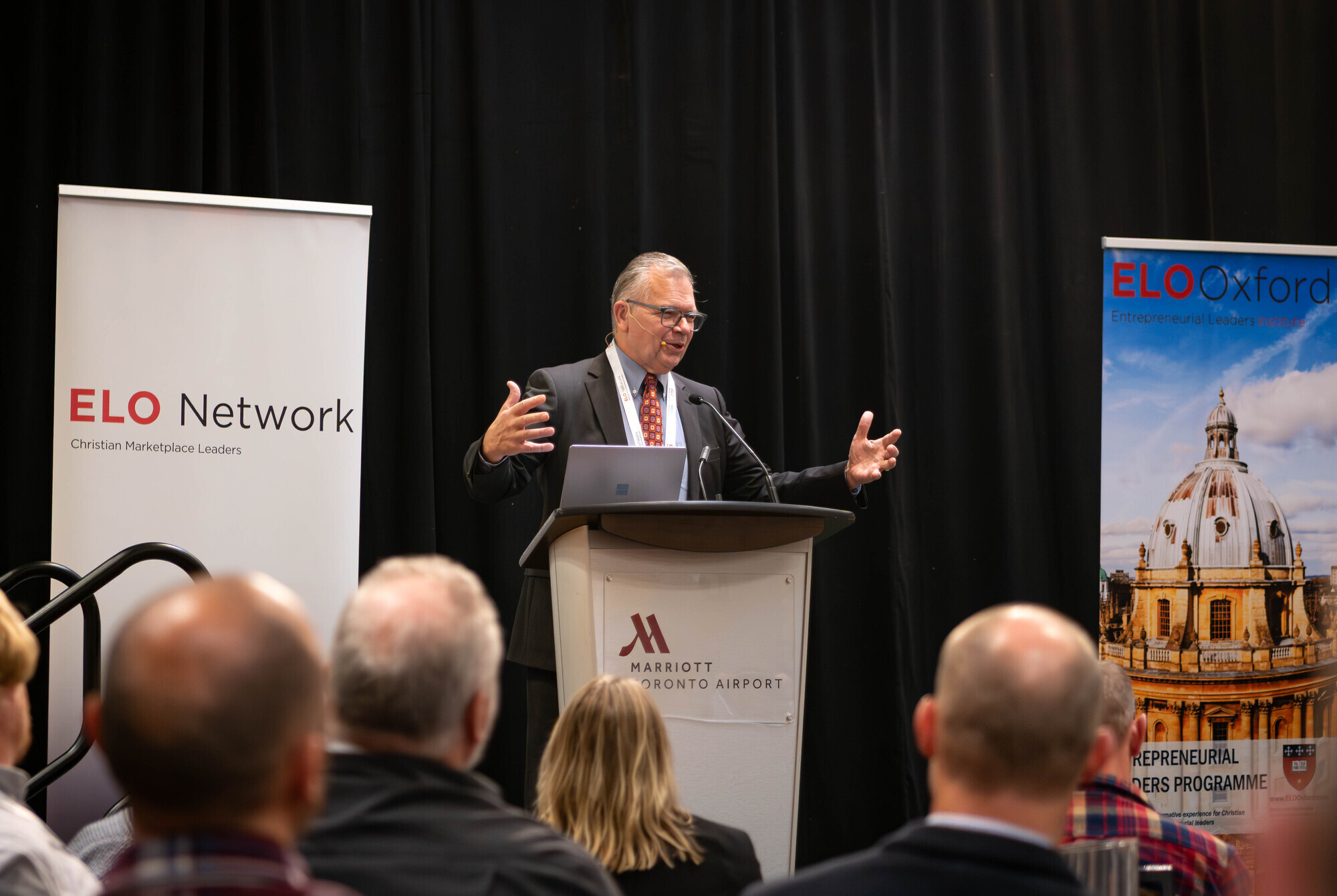 President of ELO Network Rick Goossen engages with the audience from the podium in conference room
